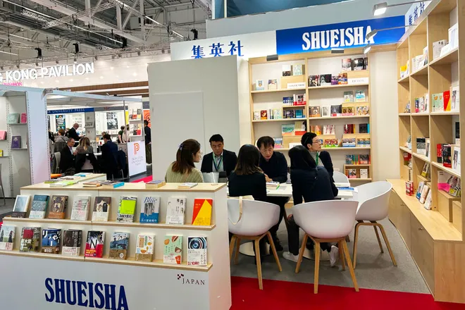 フランクフルト・メッセ会場の集英社ブースの写真。中央のミーティングデスクの周りには刊行書籍が並べられた本棚がある。
